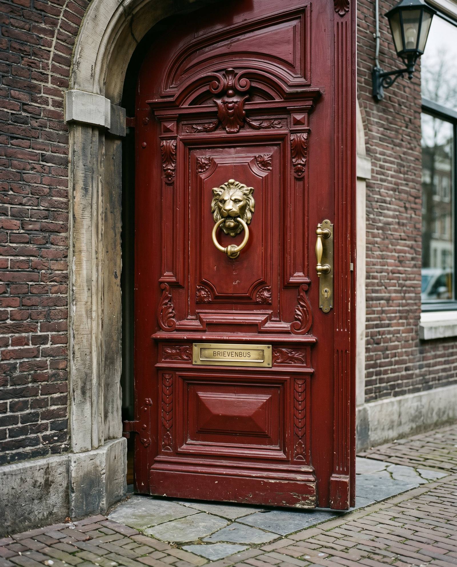 Ossenbloedrode monumentale voordeur met koperen klopper