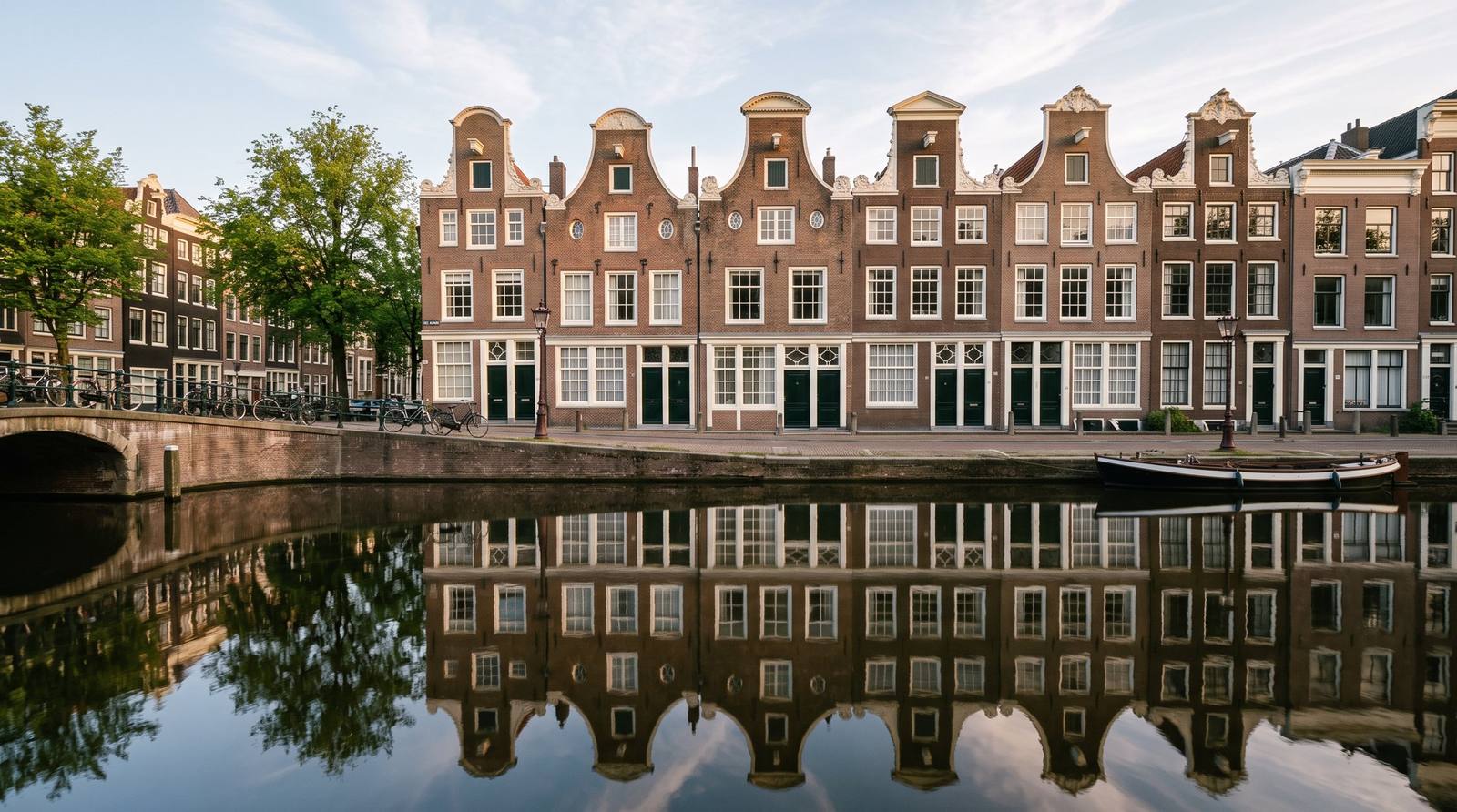 Rij grachtenpanden met witte kozijnen en groene deuren
