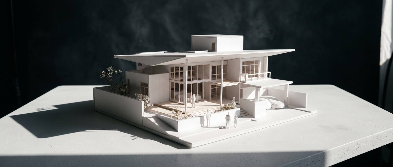 Witte studiemaquette van een woonhuis met diepe schaduw