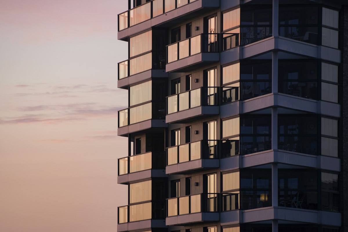 Woongebouw met glazen balkonschermen in avondlicht