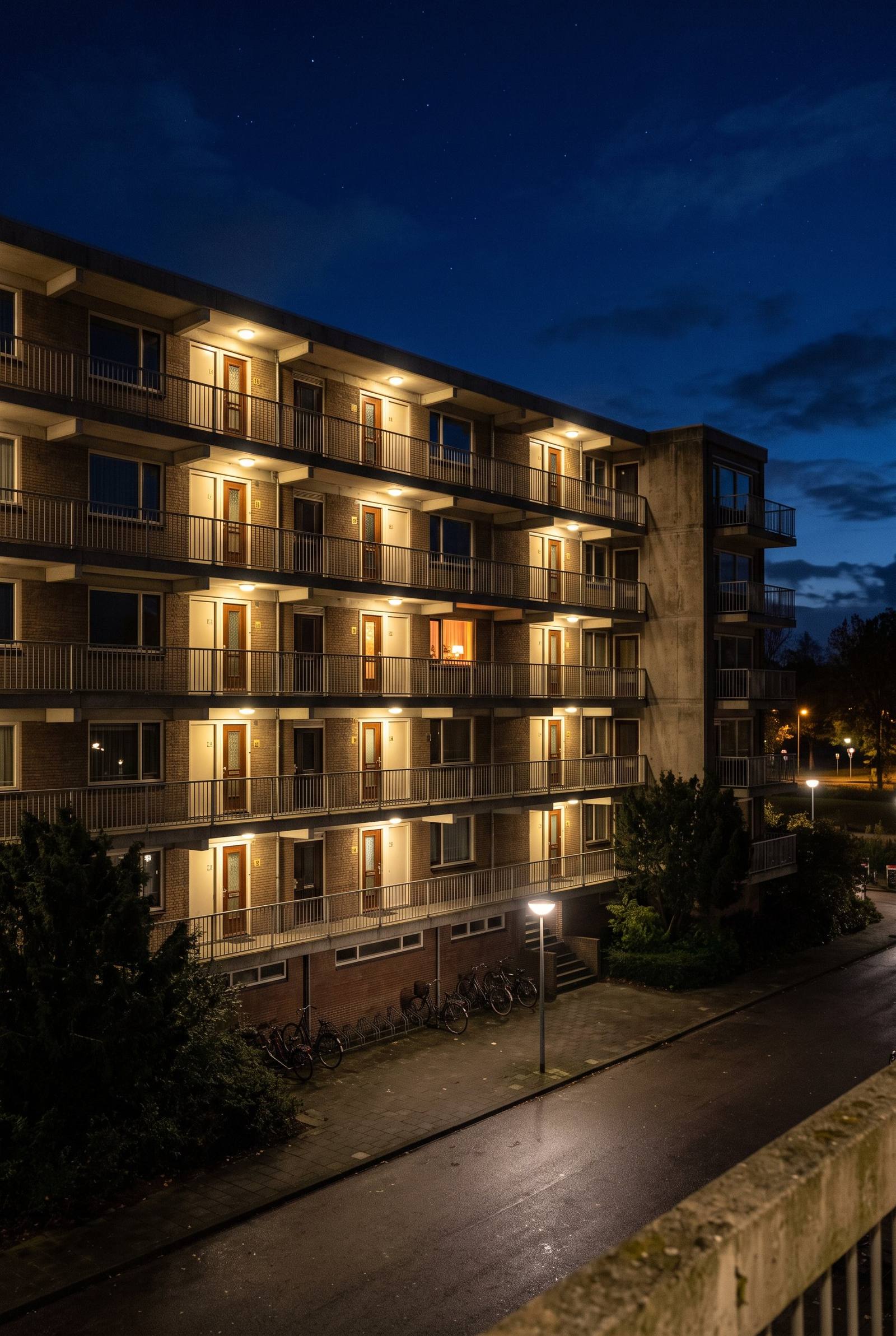 Galerijflat bij nacht met verlichte voordeuren